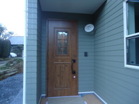 グリーンの外壁に木目の玄関+アンティーク照明